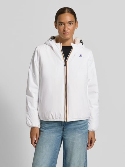 Frauenmodel trägt weiße Regular Fit Jacke mit Logo-Print Modell 'CLAUDETTE' von K-WAY, sichtbare Kapuze, elastische Abschlüsse, Ganzkörperansicht von vorne, Kontext: Damenjacke, Größe S Rückenlänge 51 cm, Schulterbreite 41 cm, Brustweite 55 cm, Ärmellänge 61 cm.