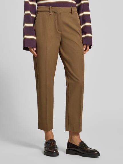 Frauenmodel trägt Regular Fit Stoffhose mit Bügelfalten von T. HILFIGER SPW., unifarben, feines Webmuster, Slim Fit, Straight Leg, seitliche Eingrifftaschen und Gesäßtaschen, Bundfalte, Ganzkörperansicht von vorne.