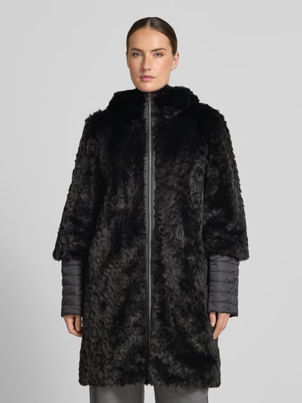 Frauenmodel trägt Mantel aus Kunstfell mit Zweiwege-Reißverschluss von Marc Cain in Schwarz mit Stehkragen, Regular Fit, Ganzkörperansicht von vorne. Rückenlänge, Schulterbreite, Brustweite und Ärmellänge bei Größe 36 aus dem Kontext berücksichtigt, Struktur mit weicher Textur.