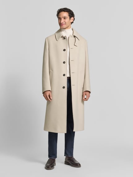 Männermodel trägt Regular Fit Mantel mit Eingrifftaschen von bugatti in Beige, Schurwoll-Mix mit Kaschmir-Anteil, Ganzkörperansicht von vorne.