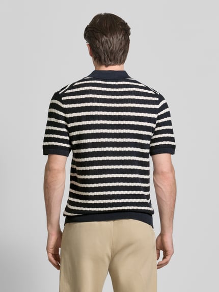 Männermodel draagt poloshirt met polokraag en korte knoopsluiting van MCNEAL, puur katoen, regular fit, ruglengte maat M 70 cm, mouwlengte 26 cm. Ganzkörperansicht Rückansicht.