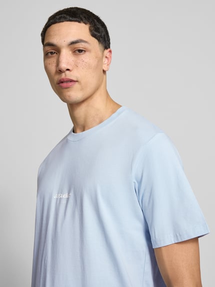 Männermodel trägt T-Shirt mit Logo und Rundhalsausschnitt von Jack & Jones, hellblau, aus reiner Bio-Baumwolle, Regular Fit, Nahaufnahme Oberkörper.