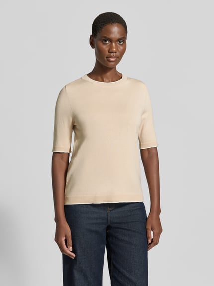 Frauenmodel trägt Regular Fit Pullover aus Viskose-Mix von s.Oliver BLACK LABEL in Beige mit glatter Textur, dunkle Jeans, Ganzkörperansicht von vorne. Damen Pullover von s.Oliver BLACK LABEL.