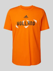T-shirt z nadrukiem z logo model ‘HOLLAND’ od ADIDAS SPORTSWEAR Pomarańczowy - 26